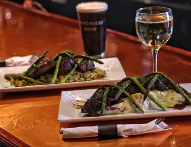 Plates of Hangar Steak accompanied with beer and wine.