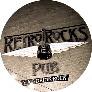Iconic logo of Retro Rocks Pub displayed on a brick wall, featuring a guitar with wings and the motto 'Eat-Drink-Rock'.